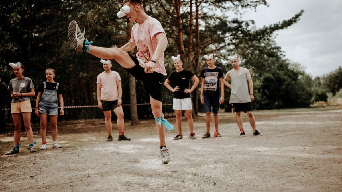 A group of people enjoying an outdoor game with fun eye covers and energetic movements.
